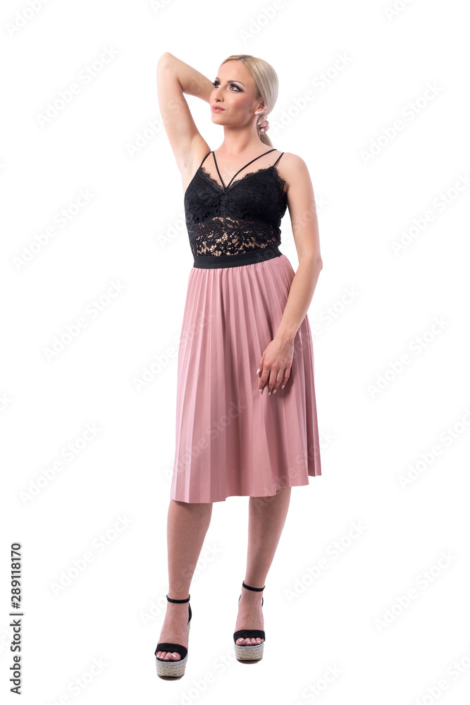 Elegant feminine gorgeous blonde fashion girl holding hair with hand looking up. Full body isolated on white background.