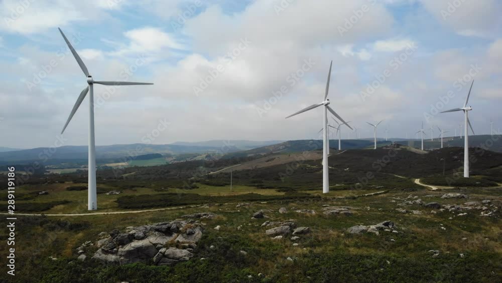 Wind turbines for clean renewable energy and natural landscape with hills and fields near Negreira in Spain, Europe. Aerial view from drone flying in the sky Wind turbines for clean renewable energy and natural landscape with hills and fields near Negreira in Spain, Europe. Aerial view from drone flying in the sky