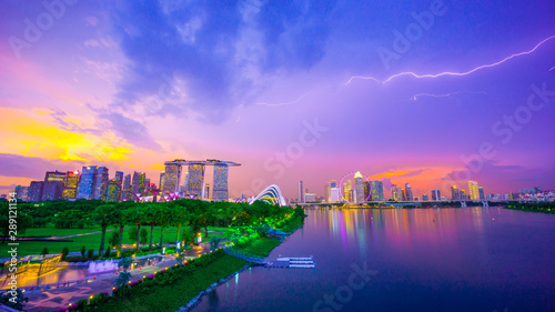 Royalty-free stock photo ID: 1488208352 Landscape of Singapore city during the twilight time and thunderbolt with marina bay sand tower, and Singapore flyer and Gardens by the Bay background. Tourist