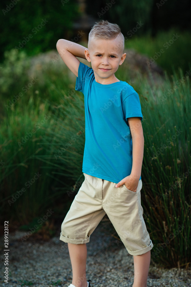 Portrait of blonde little boy posing outside Portrait of blonde little boy posing outside