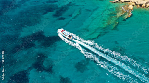 Aerial bird's eye view photo taken by drone of boat cruising in Caribbean tropical beach with turquoise - sapphire waters © aerial-drone