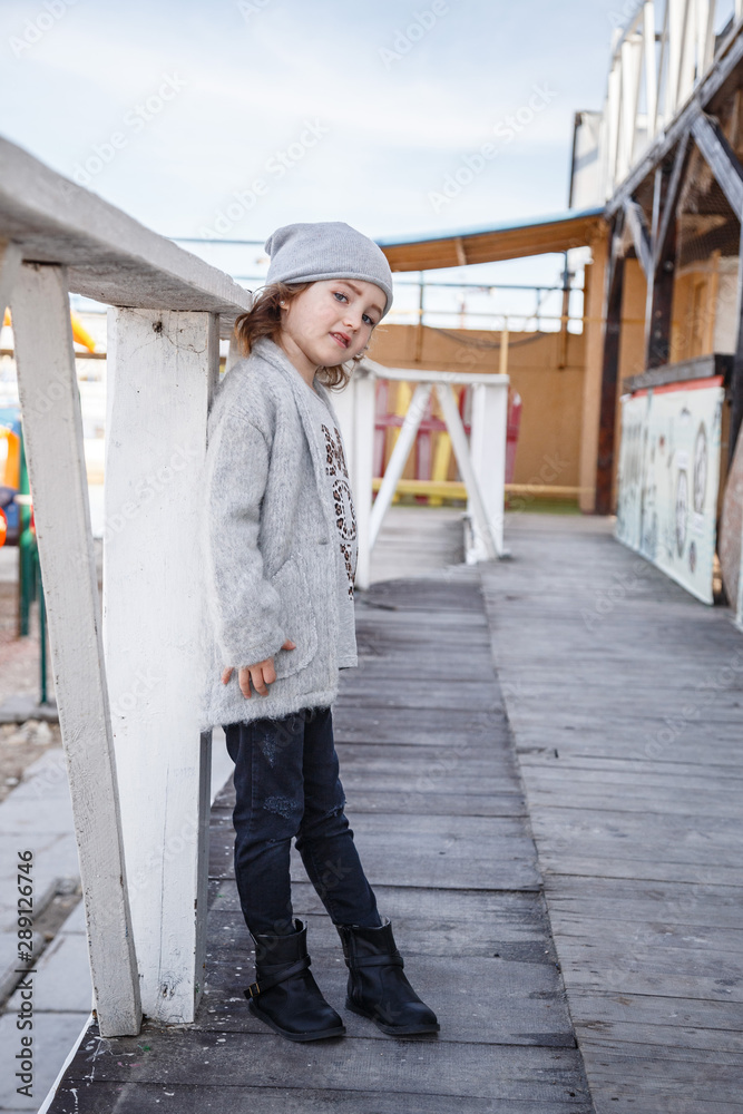A fashionable little girl in a knitwear by the sea in the fall A fashionable little girl in a knitwear by the sea in the fall