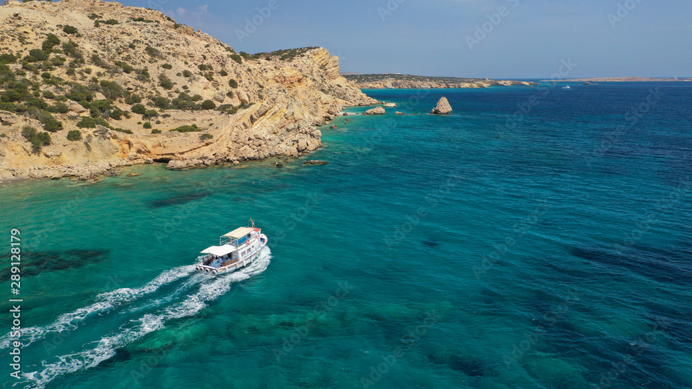 Aerial drone photo of picturesque and traditional tourist vessel cruising in famous beaches of Koufonisi island, Small Cyclades, Greece