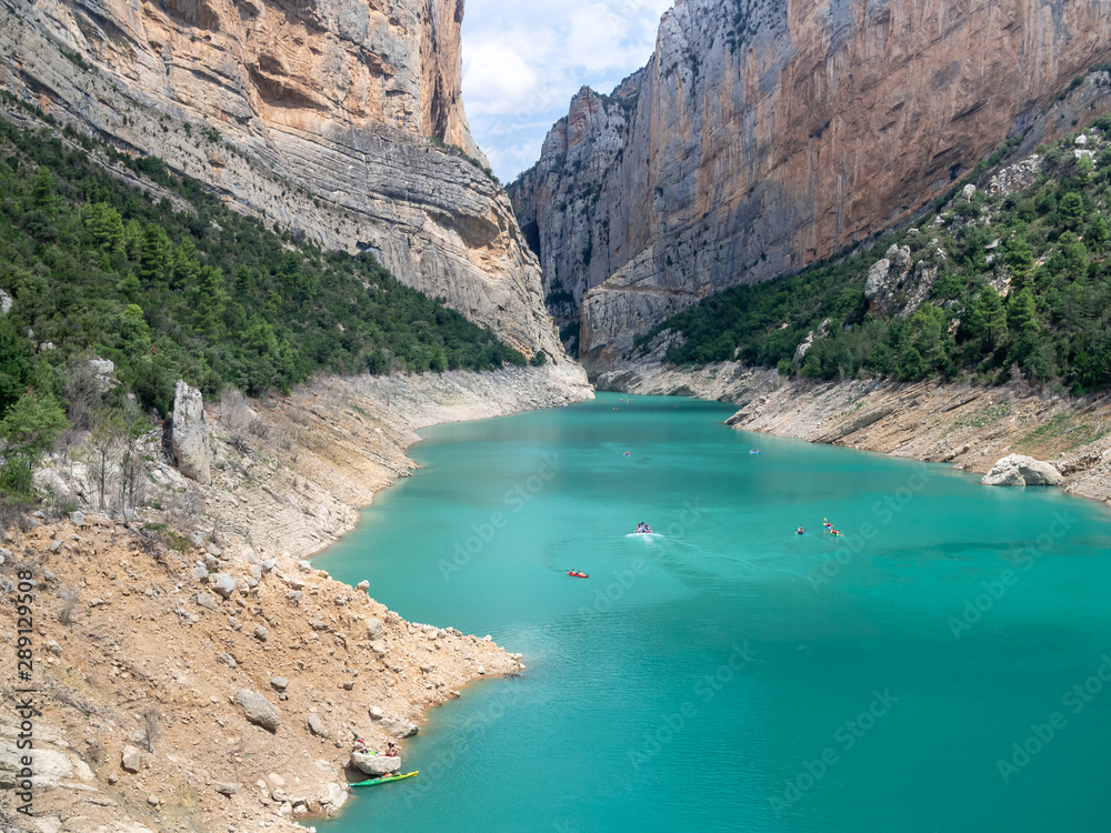 Congost de Mont-rebei (Mont-rebei gorge) at Noguera Ribagorcana river, Spain. Aerial view. Tourists in kayaks are visible on the water. Congost de Mont-rebei (Mont-rebei gorge) at Noguera Ribagorcana river, Spain. Aerial view. Tourists in kayaks are visible on the water.