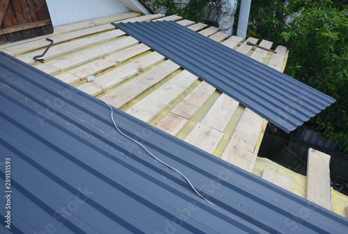 Roofing Construction. Installing  lightweight metal roof tiles roofing  construction on house roofing construction