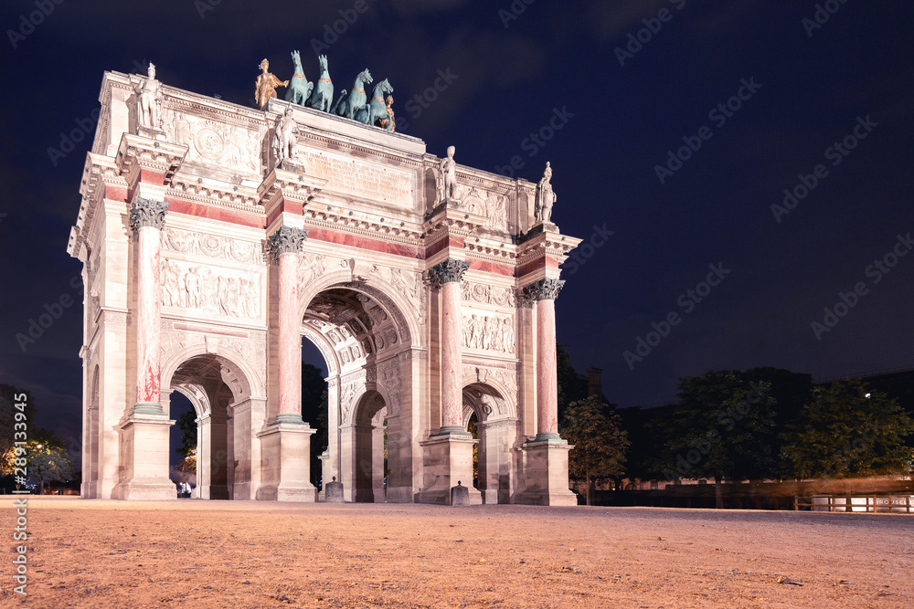 Arc de Triomphe on the Carrousel square near the Louvre museum at night, illuminated by lights and lanterns on long exposure