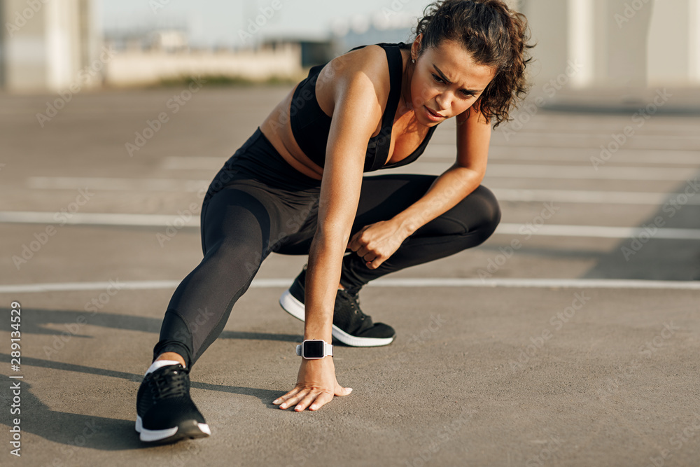 Young sport woman stretching legs. Female resting after training. Young sport woman stretching legs. Female resting after training.