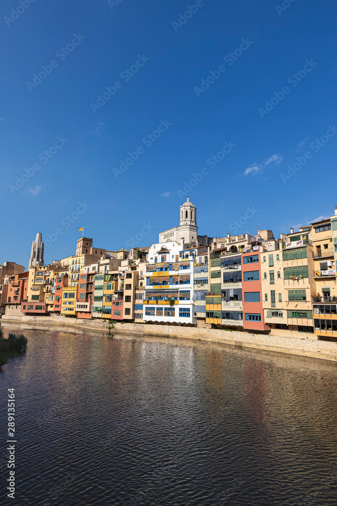 Girona's famous skyline with Cathedral and river houses on a blue sunny sky