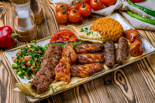 assorted kebabs with bulgur and vegetables Turkish cuisine on wooden table