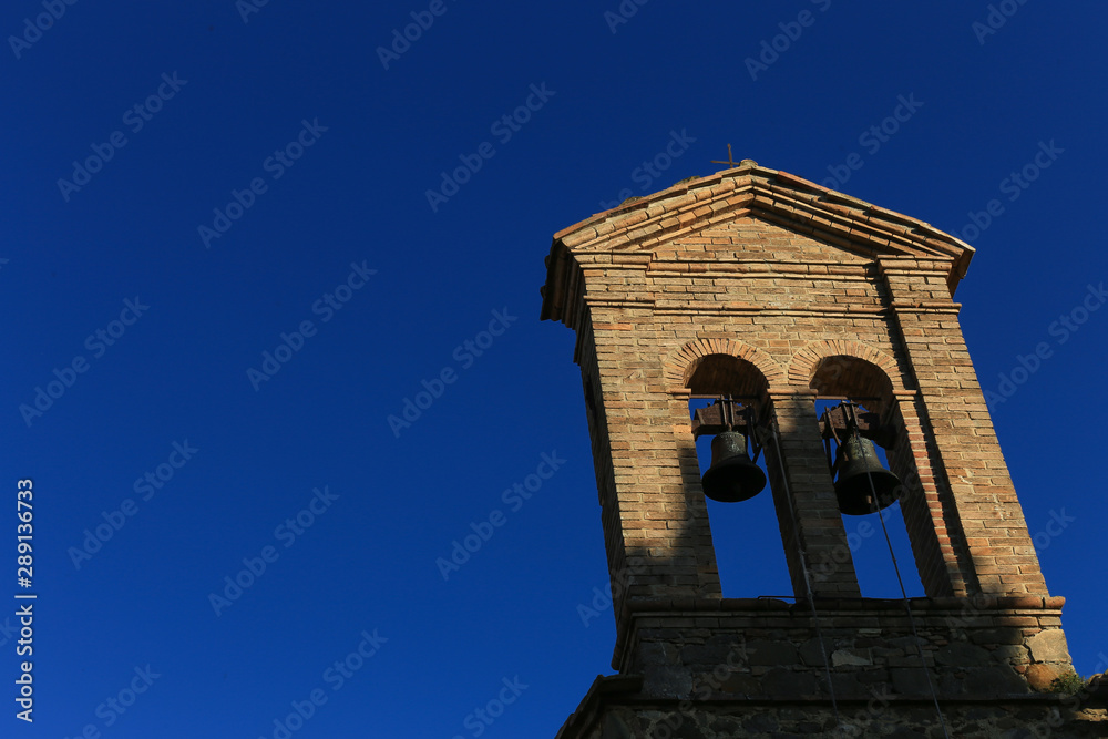 Bell tower with two bells. Church Santa Maria delle Grazie in Montalcino, Italy