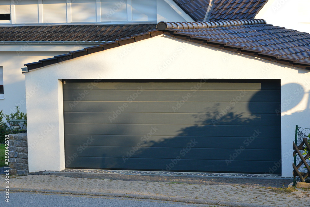 Moderne Beton-Garage mit Automatik-Tor in der Hauszufahrt Moderne Beton-Garage mit Automatik-Tor in der Hauszufahrt