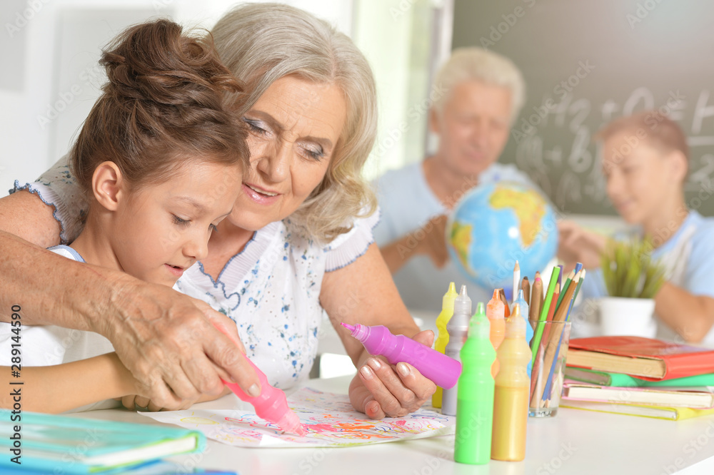 Fototapeta premium Portrait of grandmother and granddaughter drawing together