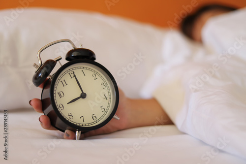 Woman hand off the alarm clock.