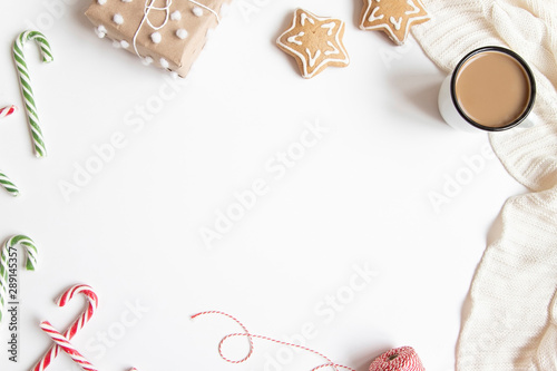 Christmas or New Year composition with presents, candy canes, coffee mug and gingerbread cookies on white background.