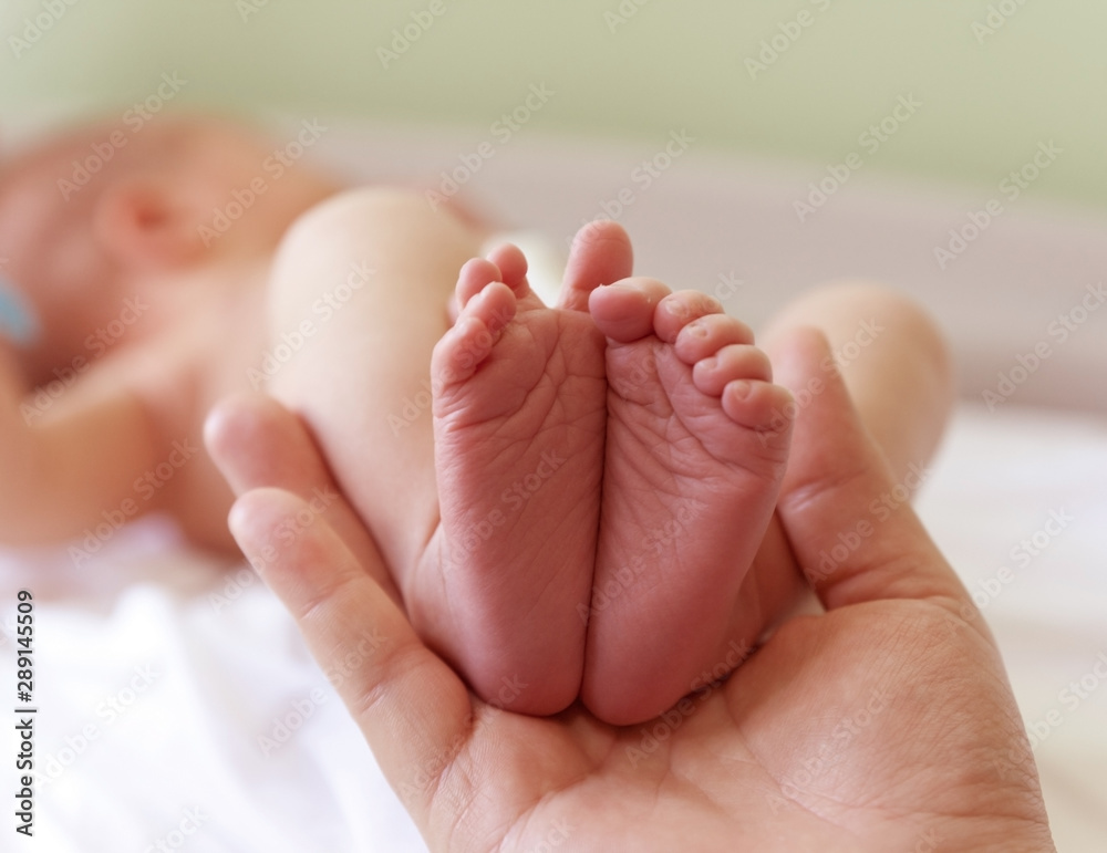 Infant heels in mother's hands Infant heels in mother's hands