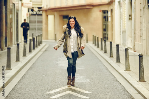 Happy woman walking through the streets of a city. © Joaquin Corbalan