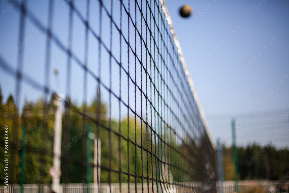 Volleyball net stretched above the ground. Sports equipment for playing ball. Sports game volleyball.