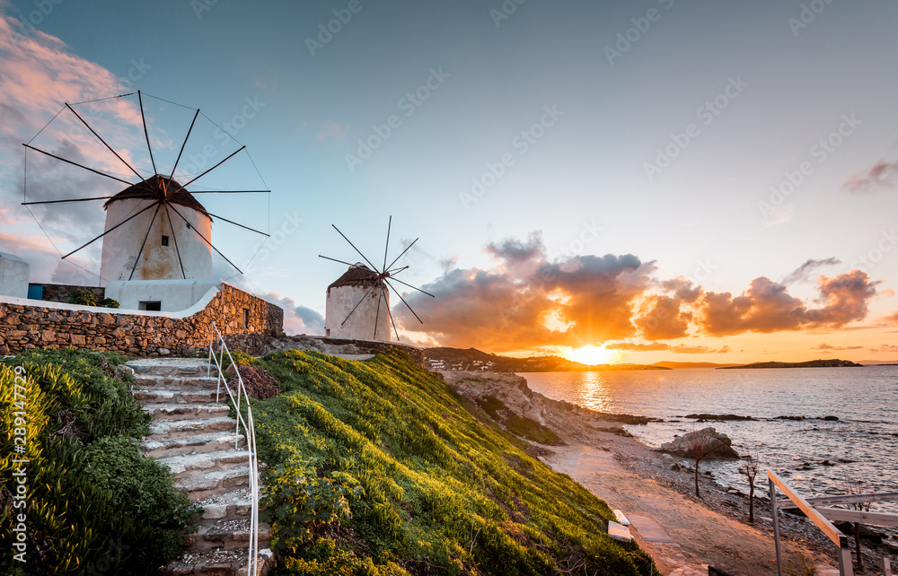 The white windmills of Mykonos Island, famous Mykonos sunset, Kato Mili close to Little Venice, Cyclades, Greece - obrazy, fototapety, plakaty 