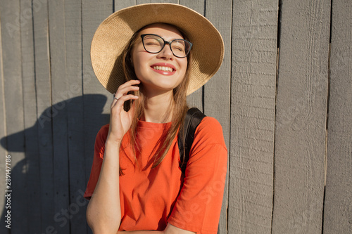Portrait of a happy woman in front of her wall. Natural smile. Sunny day. Bright stylish photo