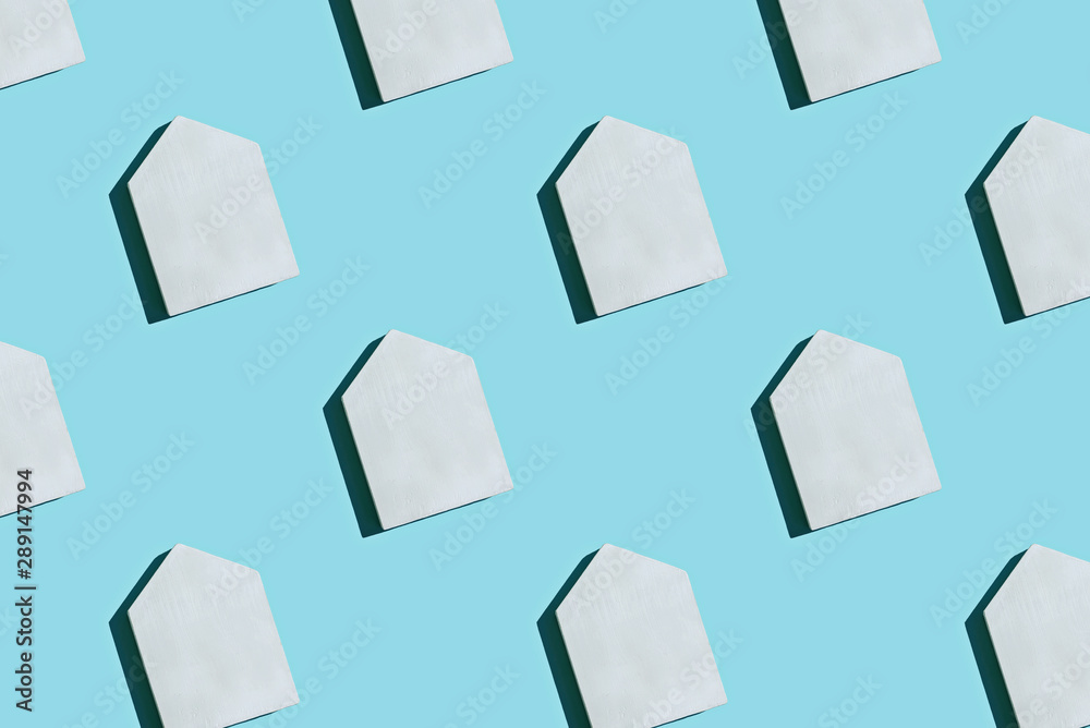 White wooden toy house pattern on blue pastel background. Creative layout. White wooden toy house pattern on blue pastel background. Creative layout.