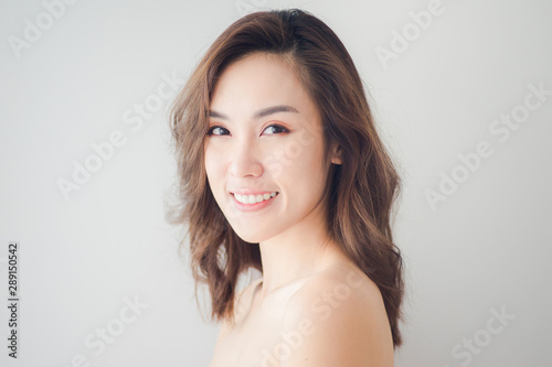 Beauty Asian Woman face Portrait. Beautiful Spa model Girl with Perfect Fresh Clean Skin. Blonde female looking at camera and smiling. Youth and Skin Care Concept