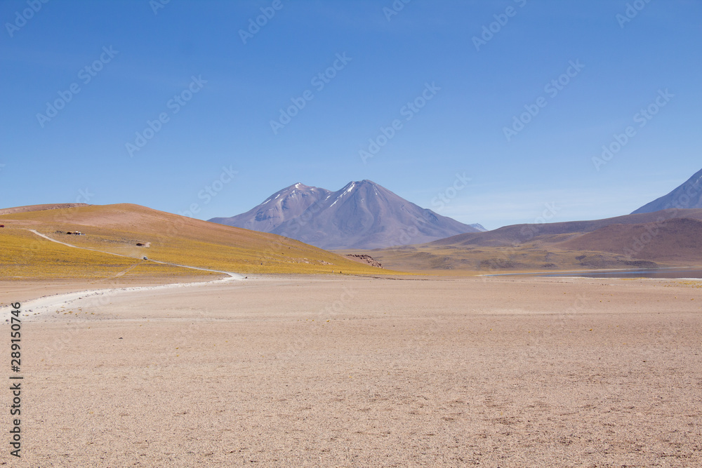 Beautiful mountain landscape with road over vast sand terrain. Atacama Desert - Chile. Miniques / Miscanti lagoons. Beautiful mountain landscape with road over vast sand terrain. Atacama Desert - Chile. Miniques / Miscanti lagoons.