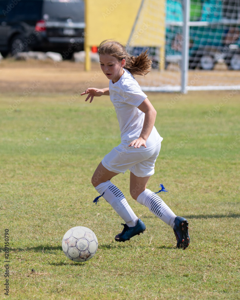 Young girl athlete playing soccer on a hot day Young girl athlete playing soccer on a hot day
