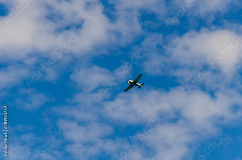 Small airplane flying in the sky with clouds
