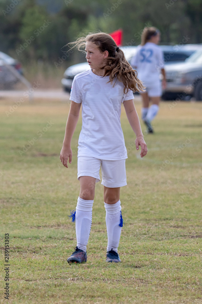 Young girl athlete playing soccer on a hot day Young girl athlete playing soccer on a hot day