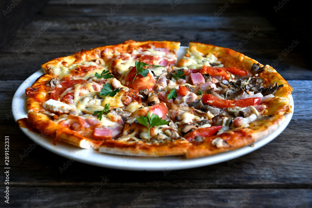 Pizza with cheese, bacon, tomato and herbs in a white bowl on a background of old boards. Pizza with cheese, bacon, tomato and herbs in a white bowl on a background of old boards.