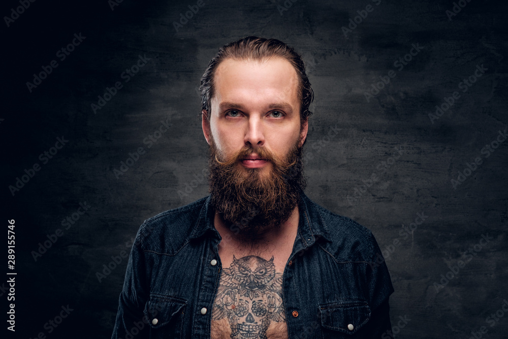Handsome bearded man is posing for photographer at dark photo studio.