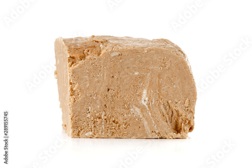 Halva on a white background. Arabian sweetness of caramel mass and ground roasted kernels of nuts, peanuts, close-up.