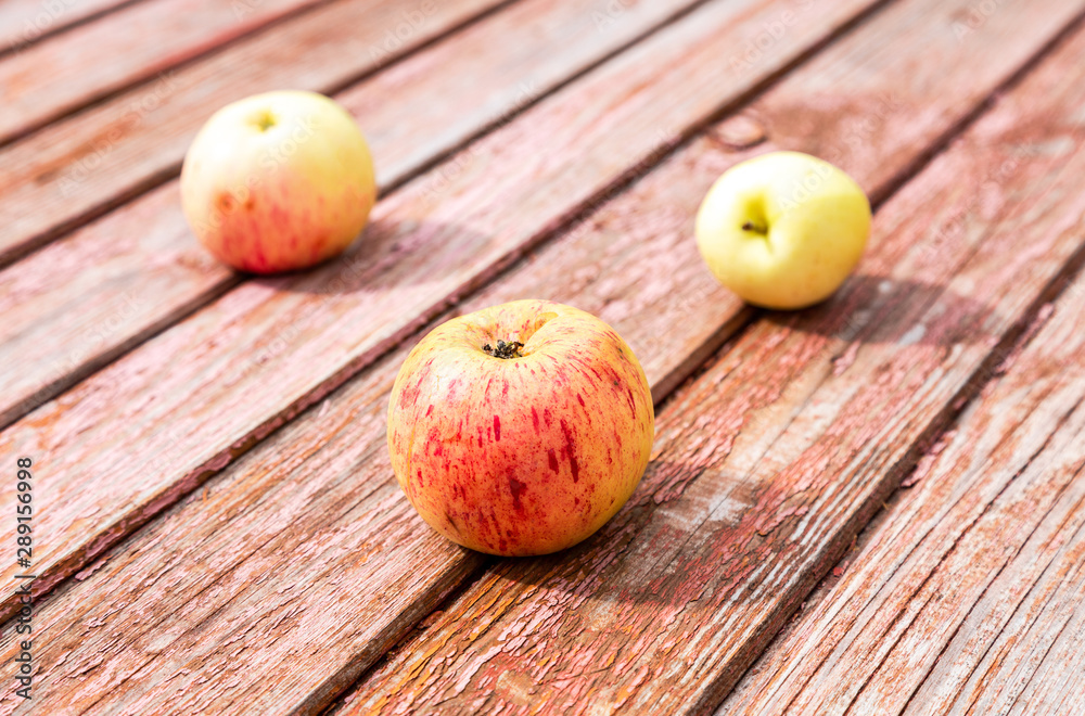 Three apples on the grunge wooden table