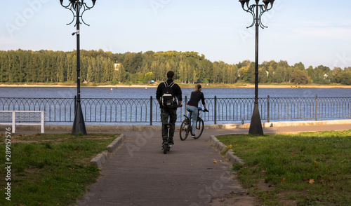 Bike at the summer sunset on the tiled road in the city park. Cycle closeup wheel on blurred summer background. Bicycle and ecology lifestyle concept. photo