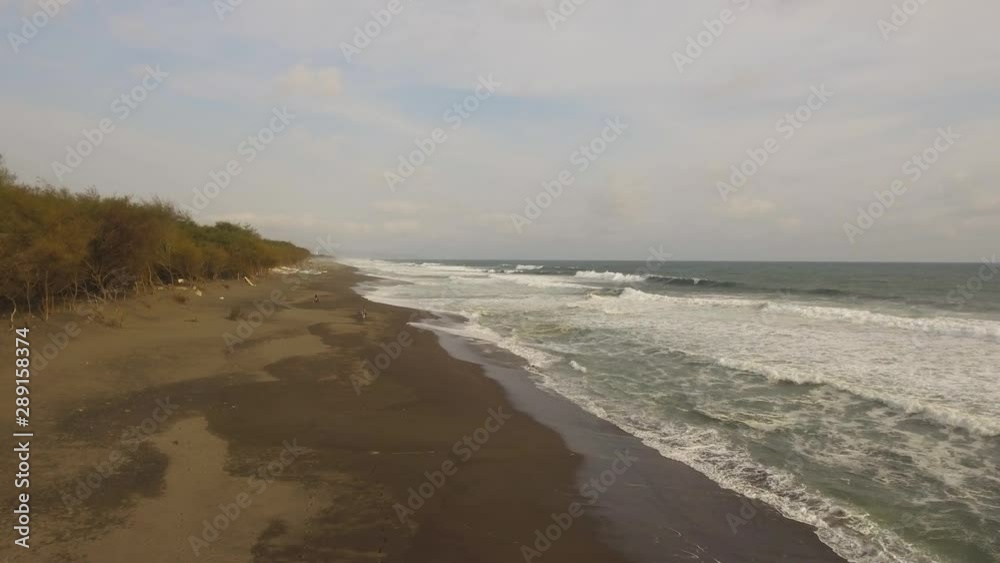 aerial view sandy beach near ocean with big waves at sunset time in tropical resort, Yogyakarta, Indonesia. seascape, ocean and beautiful beach. Travel concept. Indonesia, java aerial view sandy beach near ocean with big waves at sunset time in tropical resort, Yogyakarta, Indonesia. seascape, ocean and beautiful beach. Travel concept. Indonesia, java