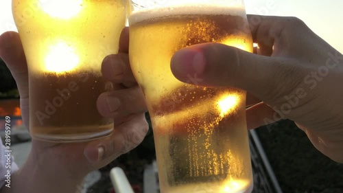toasting with cold beer mugs in summer