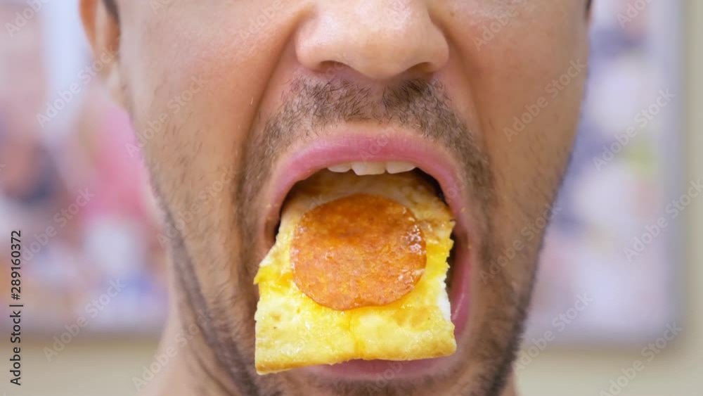 close-up. a bearded guy opens and closes his mouth, he has pizza on his tongue. copy space close-up. a bearded guy opens and closes his mouth, he has pizza on his tongue. copy space