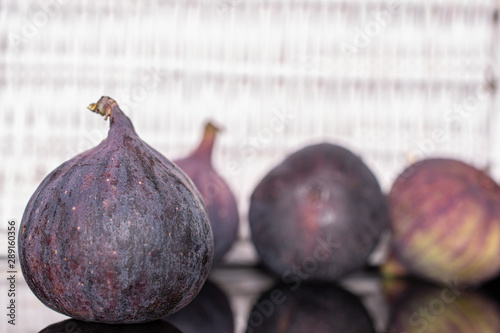 Group of four whole fresh fig fruit with white braided rattan photo