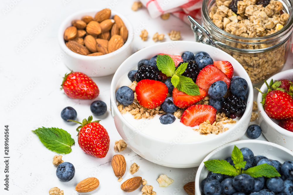 Greek yogurt granola with fresh berries on white table. Greek yogurt granola with fresh berries on white table.