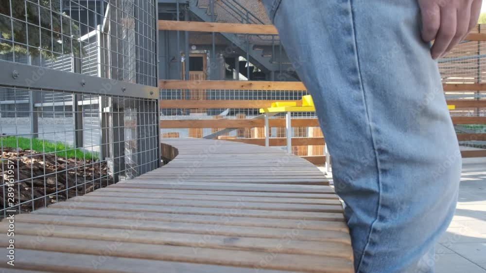 Man in blue jeans sitting down wooden bench. Man in blue jeans sitting down wooden bench.