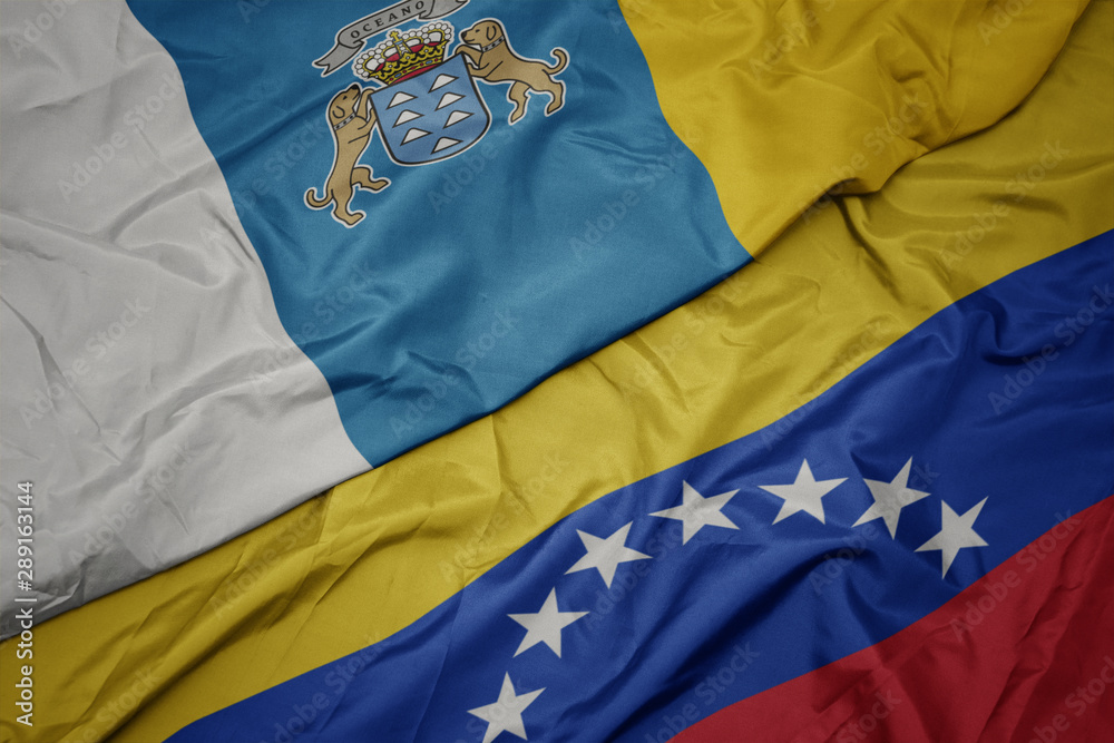 waving colorful flag of venezuela and national flag of canary islands. waving colorful flag of venezuela and national flag of canary islands.