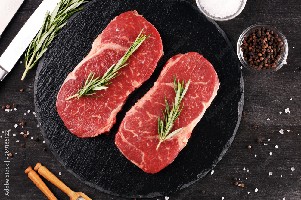 Steak raw. Barbecue Rib Eye Steak or rump steak on dark rustic table Steak raw. Barbecue Rib Eye Steak or rump steak on dark rustic table
