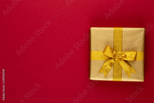 Christmas, holiday present box on red background.