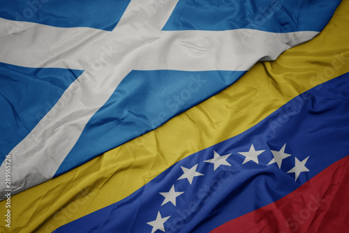 waving colorful flag of venezuela and national flag of scotland.