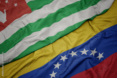 waving colorful flag of venezuela and national flag of abkhazia.