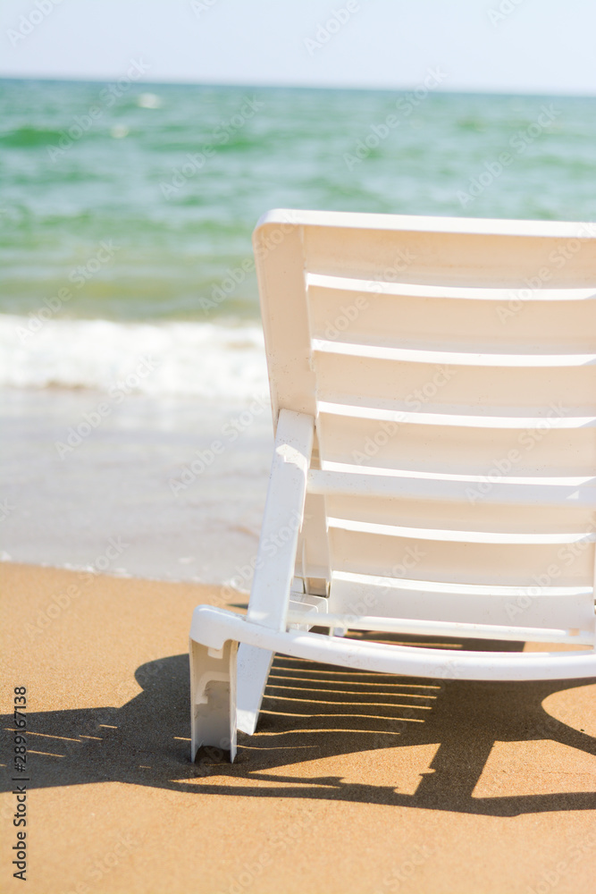 Naklejka premium Sunbed on the beach close-up on a background of the sea