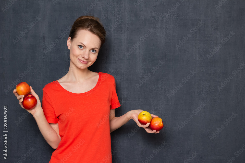 Portrait of happy girl holding ripe nectarines in hands Portrait of happy girl holding ripe nectarines in hands