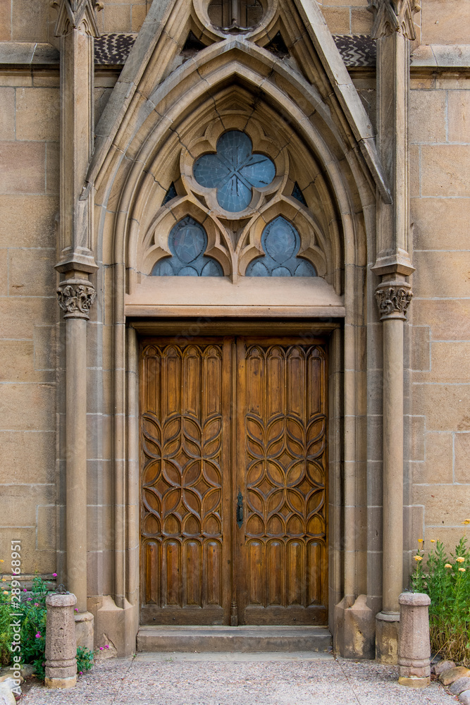 Rustic ornate wood door in a Gothic architecture facade of an old church - Loretto Chapel in Santa Fe, New Mexico