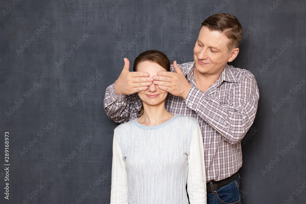 Studio shot of happy man covering eyes of cheerful woman Studio shot of happy man covering eyes of cheerful woman