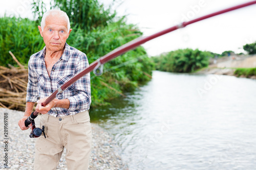 Aged fisherman pulling out catch